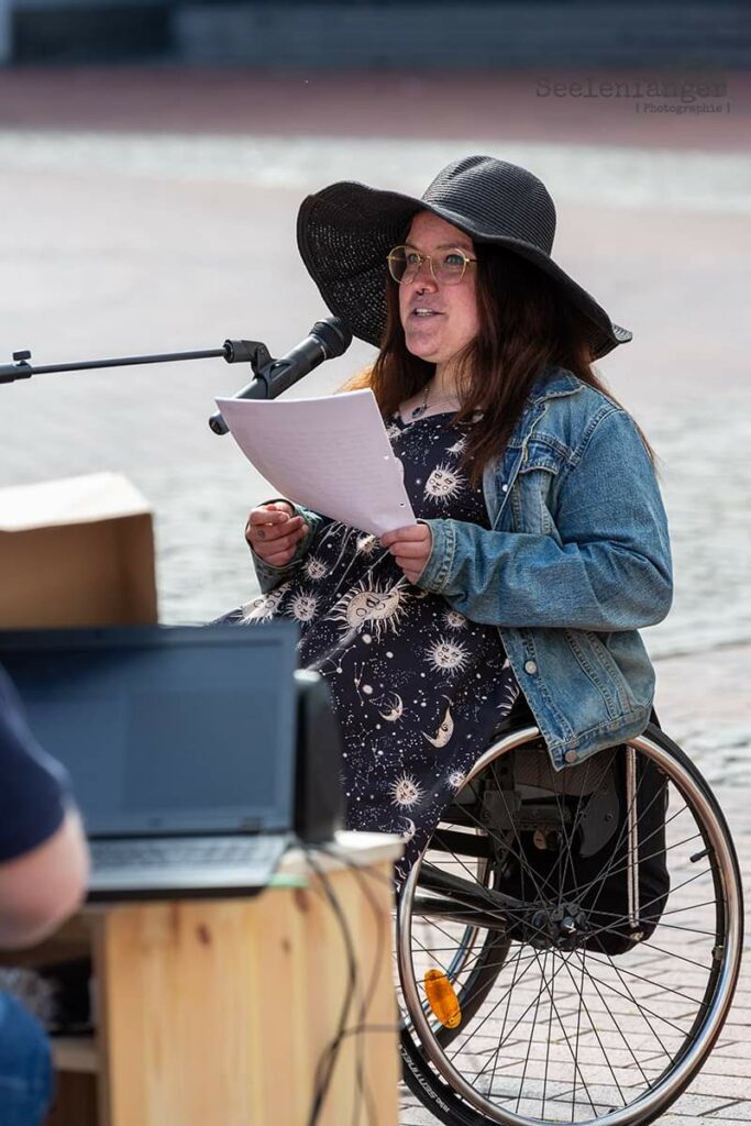 Anthea, eine Rollstuhlfahrerin beim Europäischen Protesttag zur Gleichstellung von Menschen mit Behinderung 2024, hält eine Rede